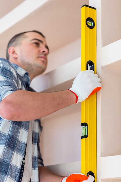 Low angle view of man holding spirit level