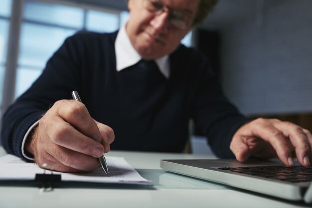 Low angle view of man writing down ideas