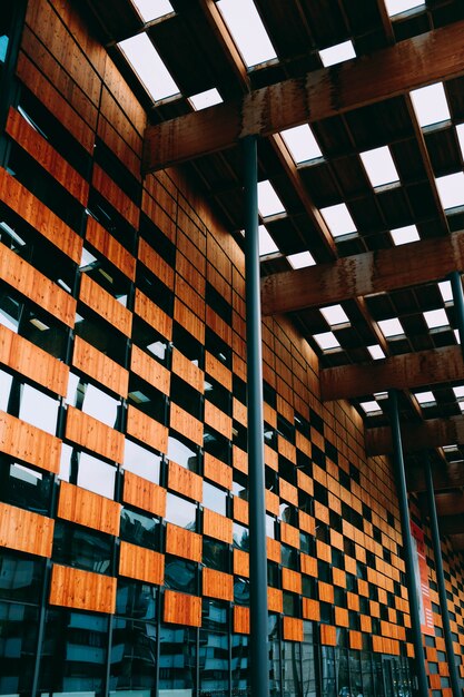 Low angle view of a modern building with wooden walls and blue windows under white lamp lights