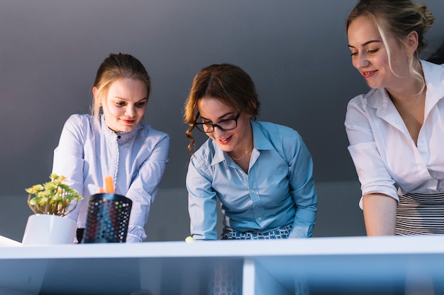 Free Photo low angle view of smiling businesswoman working on desk in the office