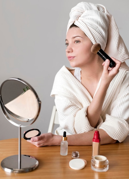 Low angle woman applying blush