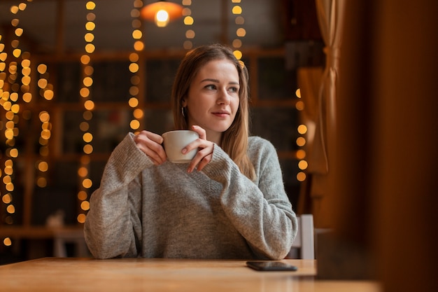 Low angle woman drinking coffee