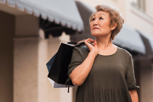 Low angle woman holding shopping bags