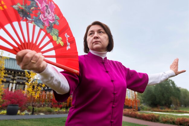 Low angle woman practicing tai chi outside