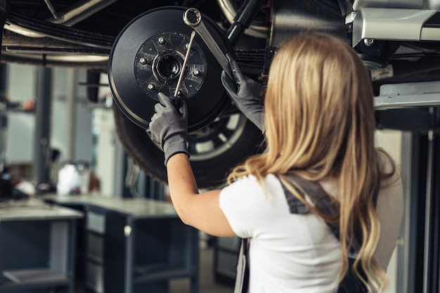 Free Photo low angle woman replacing car wheels