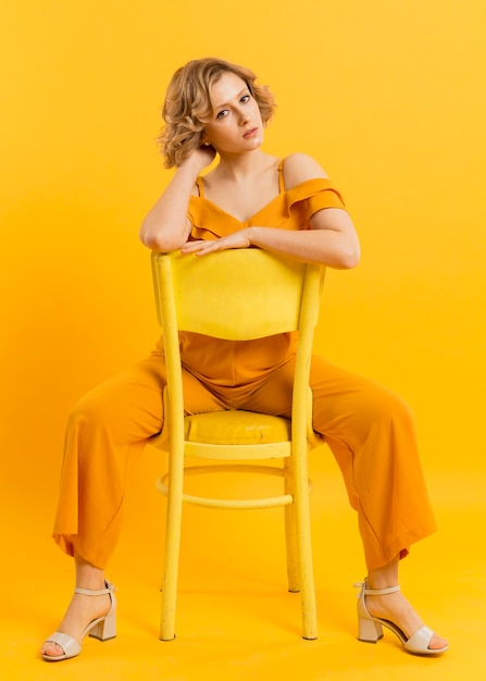 Free photo low angle woman sitting on chair