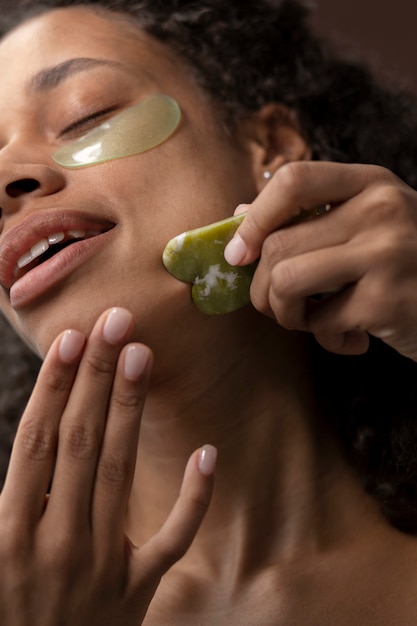 Low angle woman using gua sha