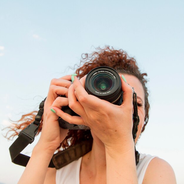 Low angle woman with camera