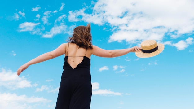 Low angle of woman with hat and sky with clouds