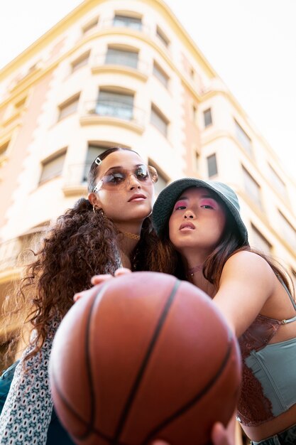 Low angle women posing with basket ball