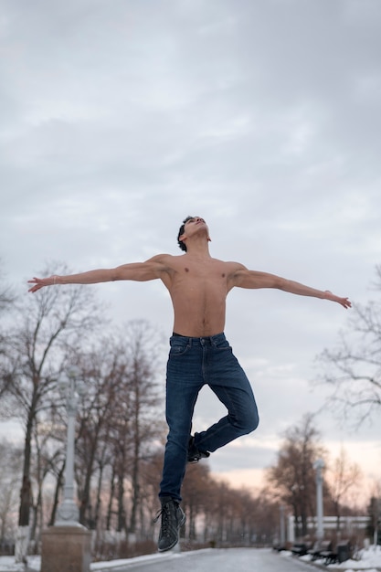 Low angle young man performing ballet outdoor