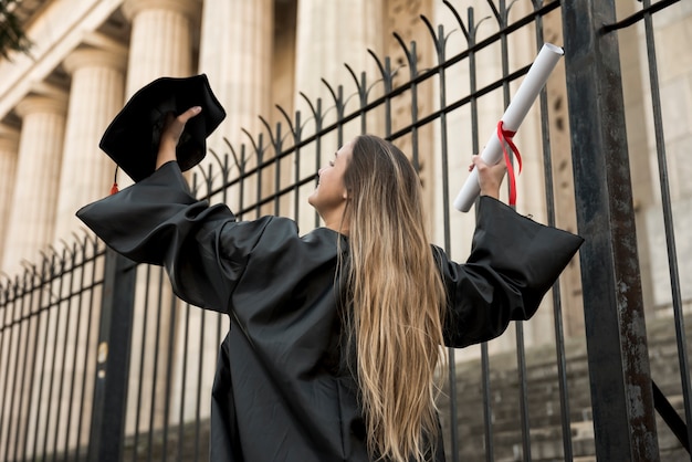 Free photo low angle young woman in academic dress