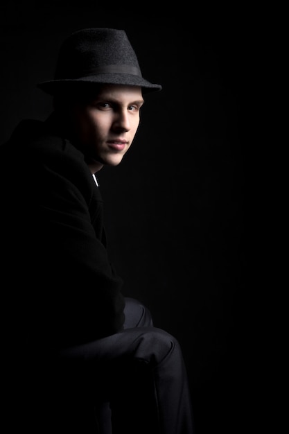 Low key shot of young man in hat