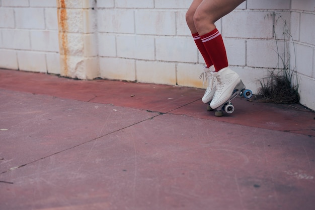 Low section of female skater balancing on roller skate