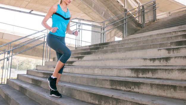 Free Photo low section of fitness young woman jogging on staircase