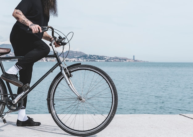 Low section of a man riding the bicycle on street near the port