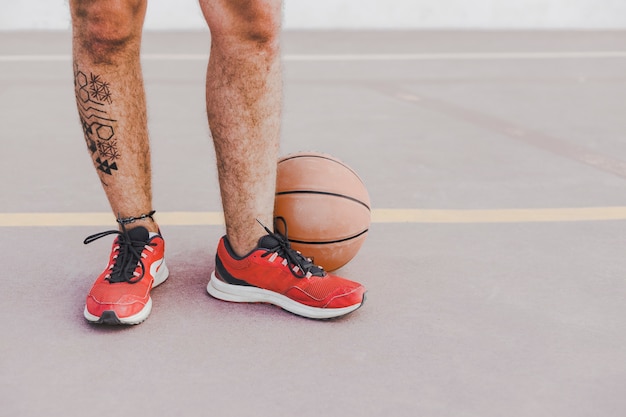 Free photo low section view of a man's feet with basketball