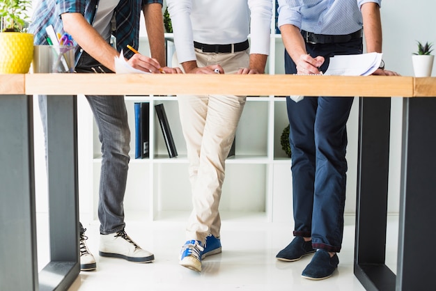 Free Photo low section view of three male architect working in office