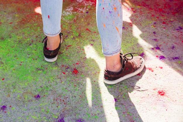 Low section of a woman's shoe mess with colorful holi colors