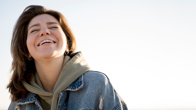 Low view portrait of smiley girl and sky