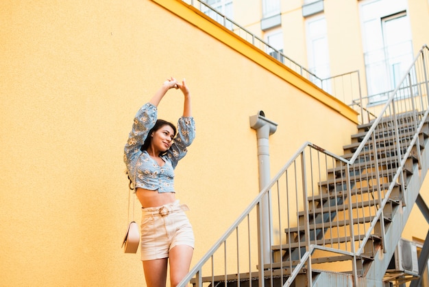 Free photo low view woman holding her hands in the air