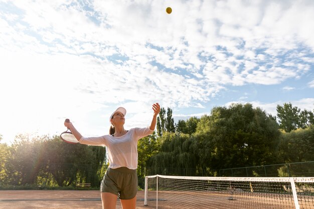 Low view woman serving during tennis match