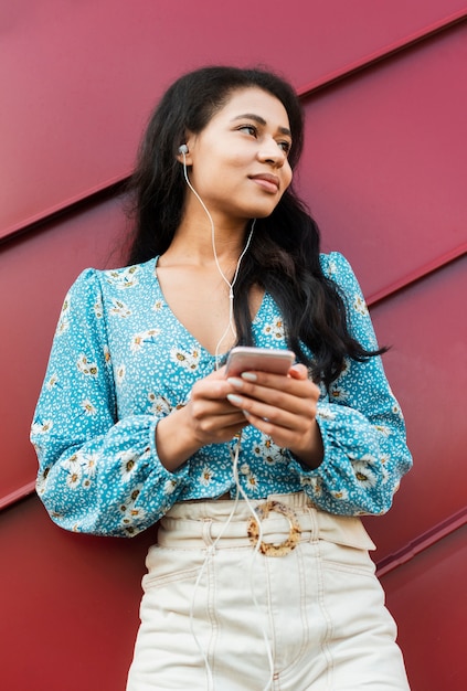 Low view woman with floral shirt and headphones