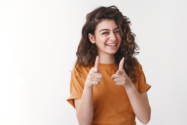 Lucky you bastard. Happy charming young female friend congratulating you pointing finger pistols camera smiling approval sister give blessing impressed brother good choice