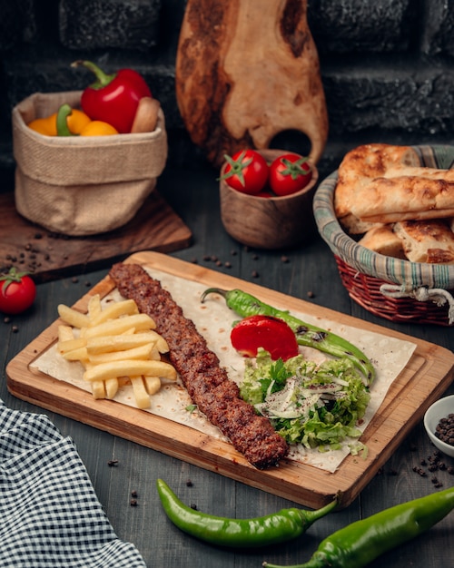 lula kebab served with french fries, salad and grilled pepper