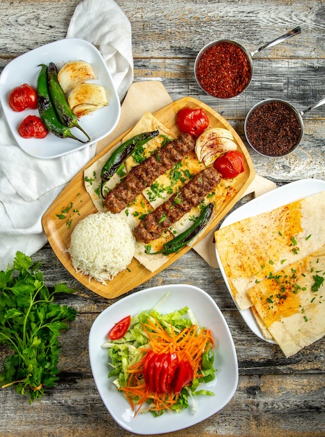 Lula kebab  with rice  salad  vegetables  top view