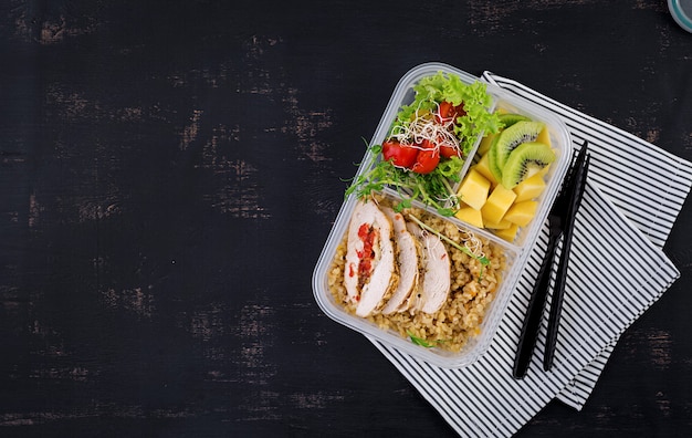 Free photo lunch box  chicken, bulgur, microgreens, tomato  and fruit. healthy fitness food. take away. lunchbox. top view