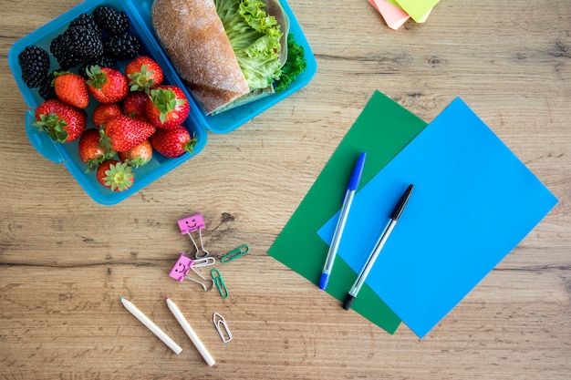 Lunch in container and copybooks on table