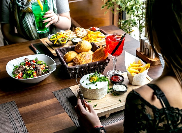 Lunch set with salad main courses bread and drinks side view