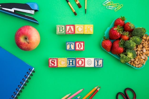 Lunchbox, wooden cubes and stationery on table