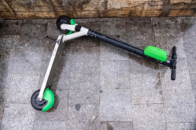 Free Photo lying electric scooter for sharing on the wet ground at cloudy weather in bucharest, romania