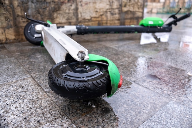 Free photo lying electric scooter for sharing on the wet ground at cloudy weather in bucharest, romania