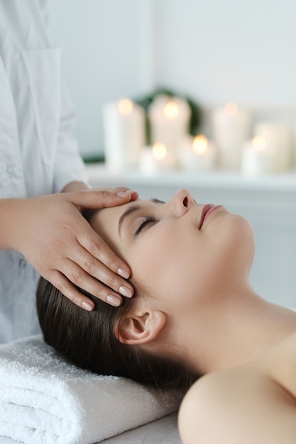 Lying woman receiving a massage. Craniosacral therapy