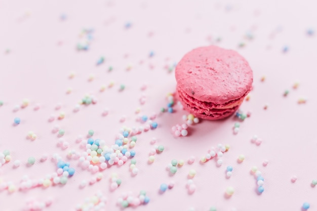 Macaroon with colorful pastel sprinkles over pink background