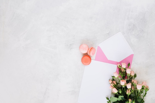 Macaroons near envelope and bouquet