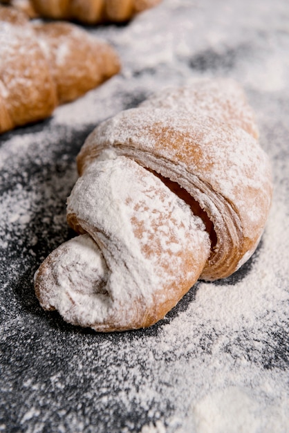 Macro picture of croissants with powdered sugar on grey table.