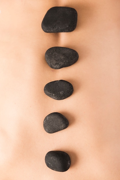 Macro shot of hot stones on woman's back