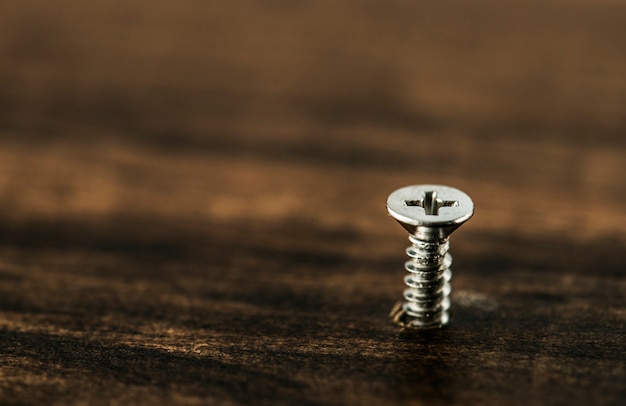 Free Photo macro shot of screw on wooden background