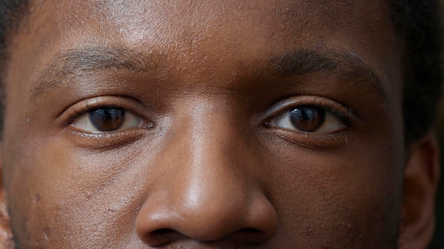 Macro shot of young adult blinking in front of camera, showing eyes with colored iris, retina and pupil. Man looking at reflection, healthy focus and eyesight. Eyebrows and eyelashes. Authentic look.