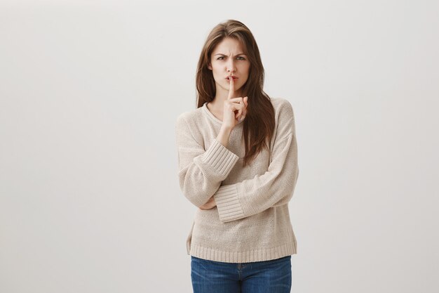 Mad grimacing woman tell be quiet, shushing at person