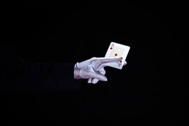 Free photo magician holding aces playing card in fingers against black background