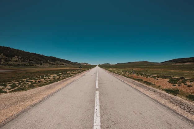 Free photo magnificent view of an endless road under the clear blue sky