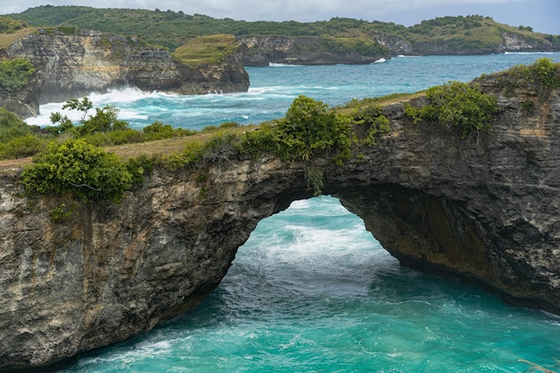 Magnificent view of unique natural rocks and cliffs formation in beautiful beach known as Angel's Billabong beach located in the east side of Nusa Penida Island, Bali, Indonesia. Aerial view.