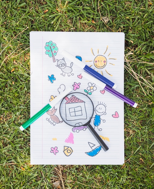 Free Photo magnifier on childish drawing on grass