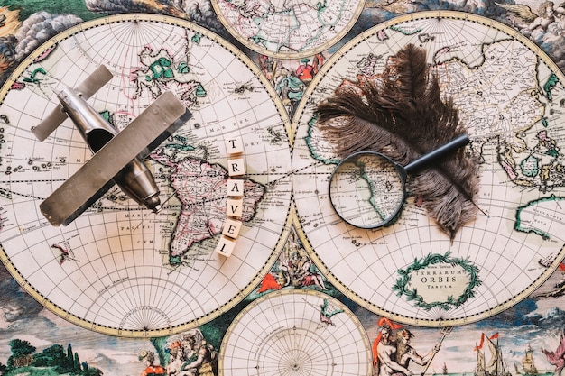 Free Photo magnifying glass and feathers near travel writing and plane