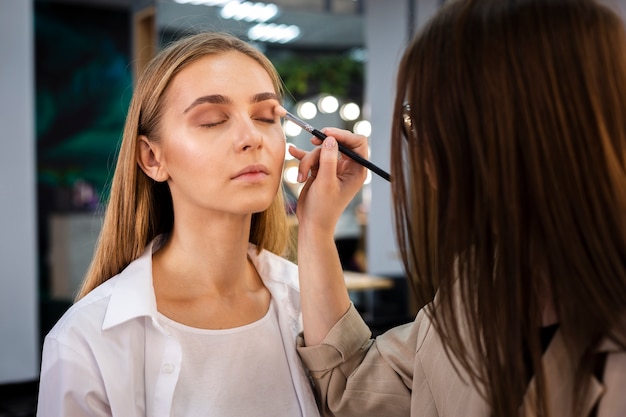 Make-up artist applying eyeshadow on face with brush